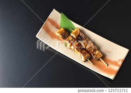 在黑色背景下拍攝的烤鰻魚串 125711711