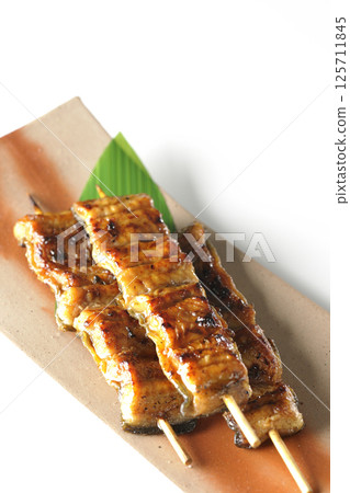 白色背景下拍攝的烤鰻魚串 白色背景下拍攝的烤鰻魚串 125711845