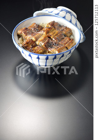 在黑色背景下拍攝的熱鰻魚飯 在黑色背景下拍攝的熱鰻魚飯 125712113