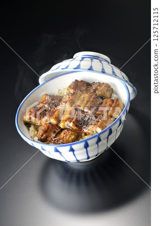 在黑色背景下拍攝的熱鰻魚飯 125712115