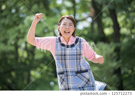 一位 40 多歲的資深護理員或幼兒園老師微笑著揮拳的照片 125712273