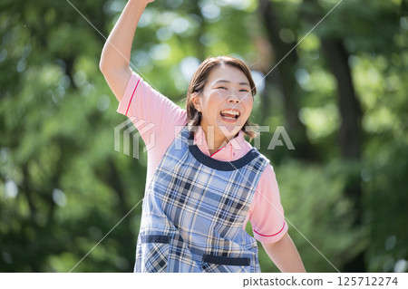 一位 40 多歲的資深護理員或幼兒園老師微笑著揮拳的照片 125712274