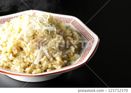Hot fried rice photographed alone against a black background Hot fried rice photographed alone against a black background 125712570