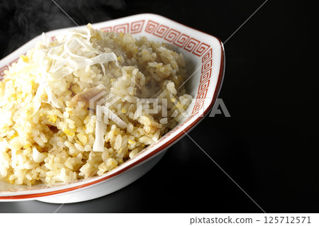Hot fried rice photographed alone against a black background Hot fried rice photographed alone against a black background 125712571
