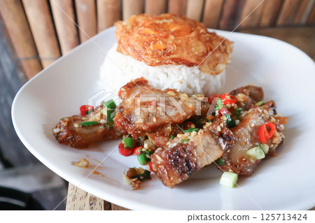 stir fried pork or deep fried pork , fried pork or crispy pork and rice with fried egg or sunny side up egg or pork and rice 125713424