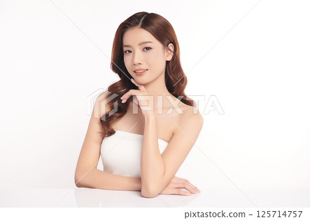 A beautiful young Asian woman with clean, fresh skin against a white background. Skincare, facial treatment, cosmetology, beauty, and spa. An elegant portrait of an Asian woman. A beautiful young Asian woman with clean, fresh skin against a white background. Skincare, facial treatment, cosmetology, beauty, and spa. An elegant portrait of an Asian woman. 125714757