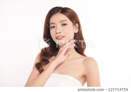 A beautiful young Asian woman with clean, fresh skin against a white background. Skincare, facial treatment, cosmetology, beauty, and spa. An elegant portrait of an Asian woman. 125714759