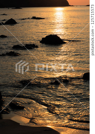 夕陽下波光粼粼的霧濱海灘 125715573