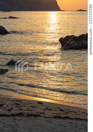 夕陽下波光粼粼的霧濱海灘 夕陽下波光粼粼的霧濱海灘 125715580