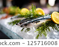 Fresh mackerel on ice with lemon slices and herbs 125716008