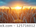 Fantastic scene of a wine glass floating in a golden wheat field and a sunset 125716012
