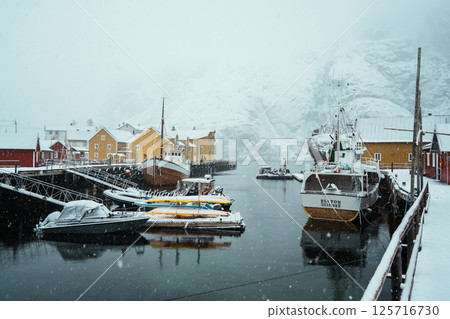 A colorful village by Snowy Fjord in Winter. Nusfjord, Lofoten. A colorful village by Snowy Fjord in Winter. Nusfjord, Lofoten. 125716730