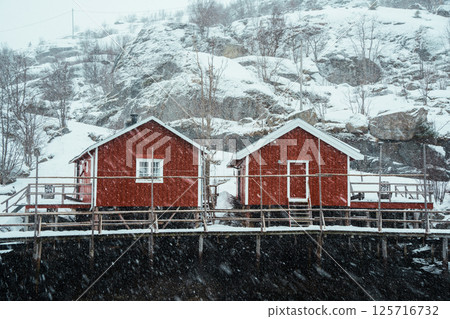 A colorful village by Snowy Fjord in Winter. Nusfjord, Lofoten. A colorful village by Snowy Fjord in Winter. Nusfjord, Lofoten. 125716732