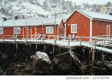 A colorful village by Snowy Fjord in Winter. Nusfjord, Lofoten. 125716744