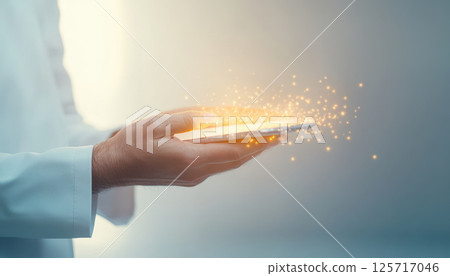 doctor hands hold smartphone emitting magical sparks, symbolizing innovation and technology in healthcare. image captures moment of wonder and advancement 125717046