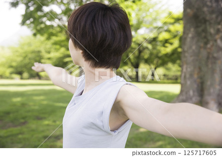 Woman doing warrior pose II outdoors Outdoor yoga image 125717605