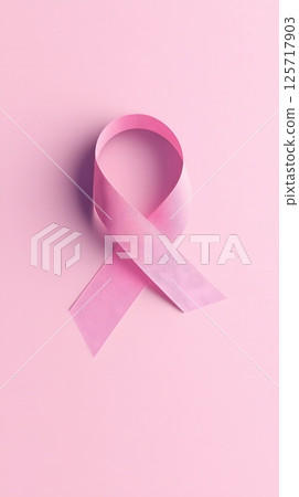 Serene presentation of a minimalist pink ribbon on a soft pink background with subtle accents. Minimalist design concept 125717903