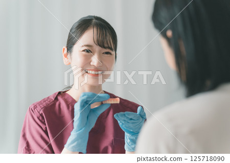 A woman in her 50s getting dentures made at a dental clinic 125718090