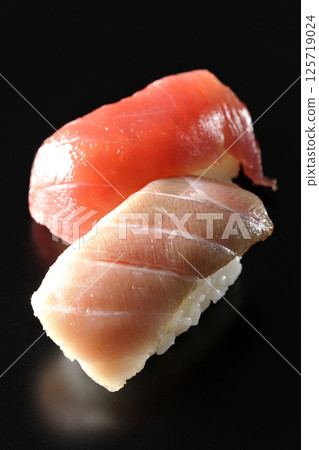 Fatty tuna and lean nigiri photographed against a black background 125719024