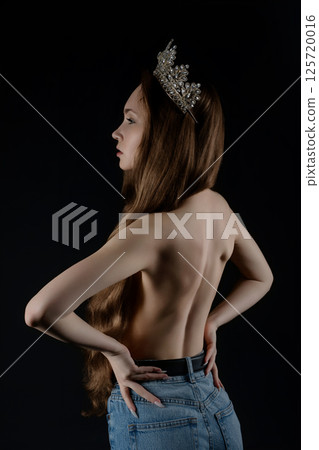 Model poses elegantly with crown showcasing beauty and confidence in studio Model poses elegantly with crown showcasing beauty and confidence in studio 125720016