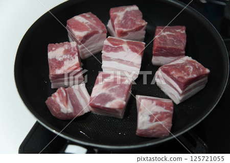 在煎鍋裡煮豬肉塊 在煎鍋裡煮豬肉塊 125721055