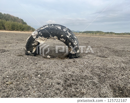Tire buried in the sand 125722187