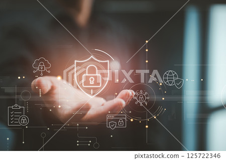 A hand displays a glowing padlock shield, symbolizing digital security and protection against cyber threats. 125722346