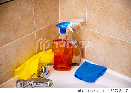 Spray detergents, cleaning bathroom tube and water tap, yellow gloves and fibber cloth 125722447