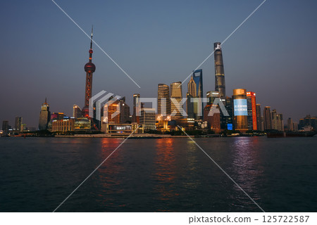 Shanghai, China - 1 April 2025: Twilight panorama of Pudong's financial district from The Bund, showcasing glowing Oriental Pearl Tower and glittering skyscrapers along Huangpu River Shanghai, China - 1 April 2025: Twilight panorama of Pudong's financial district from The Bund, showcasing glowing Oriental Pearl Tower and glittering skyscrapers along Huangpu River 125722587