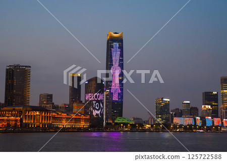 Shanghai, China - 1 April 2025: Night view of glowing Pudong skyline across the Huangpu River, illuminated skyscrapers reflecting on water 125722588