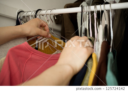 Woman choosing clothes from her closet 125724142