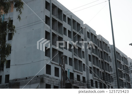 An Apartment Building Still Under Construction Featuring an Unfinished Facade Design 125725423