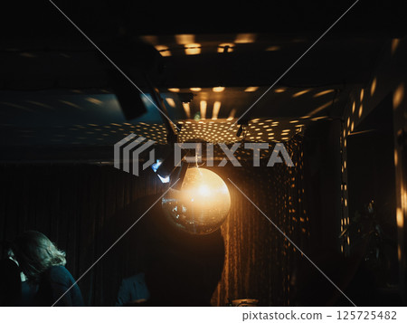 Disco Ball Reflections in a Room Dimly Lit, Exuding a Unique and Fun Atmosphere to Enjoy 125725482