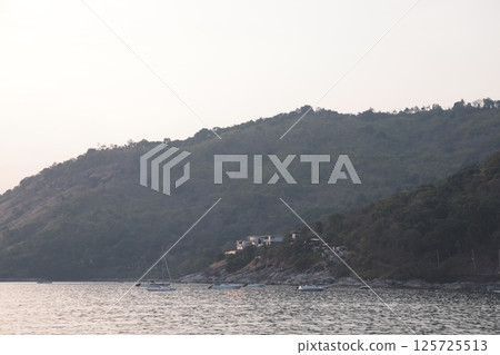 Serene Coastal Landscape Featuring Gentle Waves and Lush Rolling Hills Surrounded by Nature Serene Coastal Landscape Featuring Gentle Waves and Lush Rolling Hills Surrounded by Nature 125725513