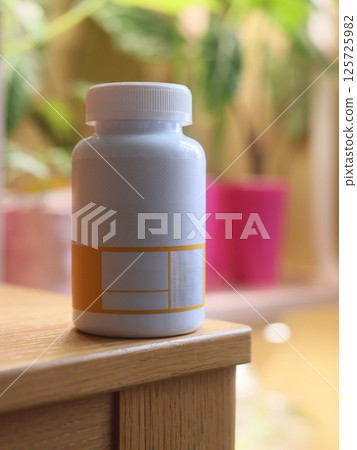 A Minimalist White Supplement Bottle Featuring a Distinctive Orange Label Design A Minimalist White Supplement Bottle Featuring a Distinctive Orange Label Design 125725982