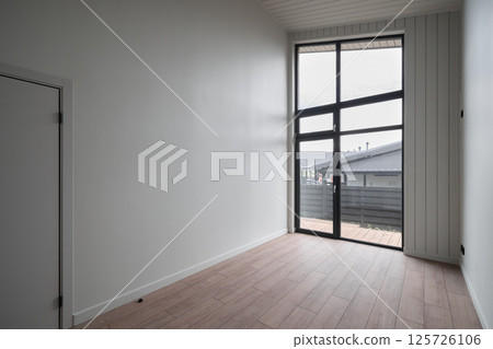 A modern interior space that features large windows allowing for an abundance of natural light 125726106