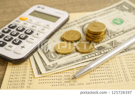Coins money with calculator and pen on bookbank finance. 125726397