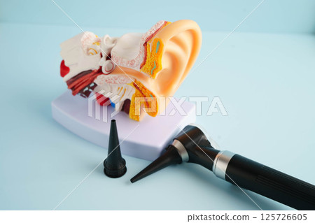 Otoscope with ear model for otolaryngologist or ENT physician doctor examining senior patient ear, hearing loss problem. 125726605