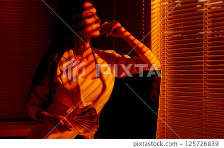 Confident Woman in Sunset Office Holding Cash Fan. 125726839