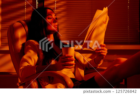 Businesswoman Relaxing with Documents and Coffee After Work. Businesswoman Relaxing with Documents and Coffee After Work. 125726842