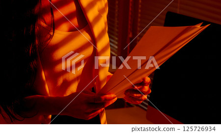 Closeup of Woman Holding Paper Documents in Office Light. 125726934