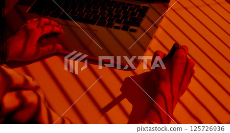 Creative Woman Drawing with Stylus near Laptop under Blinds Shadows. 125726936