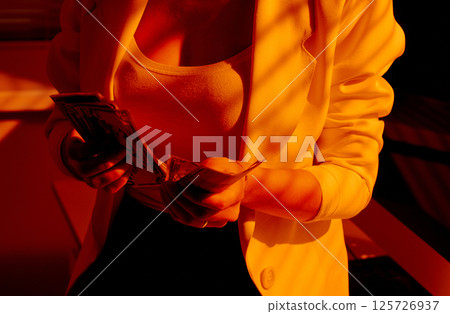 Businesswoman Counting Cash in Warm Office Lighting. Businesswoman Counting Cash in Warm Office Lighting. 125726937