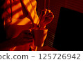 Woman Stirring Drink in Mug under Warm Office Light. 125726942
