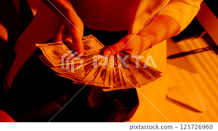 Close-Up of Female Hands Holding a Fan of US Dollar Bills. Close-Up of Female Hands Holding a Fan of US Dollar Bills. 125726960