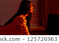 Focused Woman Working at Computer in Warm Office Light. 125726963