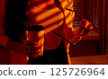 Business Woman Holding Coffee and Glasses in Warm Office Light. 125726964