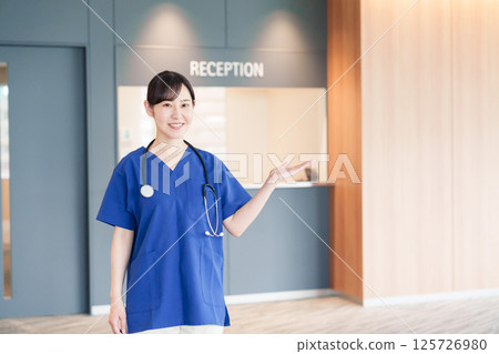 A female medical worker welcoming a patient A female medical worker welcoming a patient 125726980