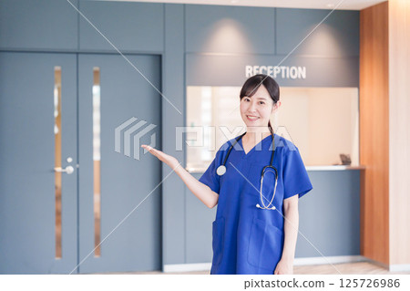 A female medical worker welcoming a patient A female medical worker welcoming a patient 125726986
