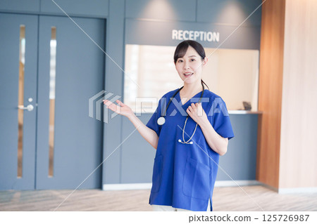 一名女醫務人員正在接待患者 一名女醫務人員正在接待患者 125726987